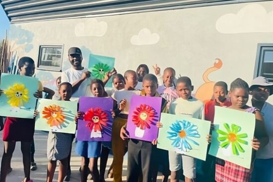 Chris Ngwenya, Green Kidz facilitators at the Makrepeni Nourish Eco Village proudly showcases the artwork of the children, who all walk to the centre from their various villages near Gowrie Gate on the outskirts of the Sabi Sands Game Reserve. Photo: Supplied.