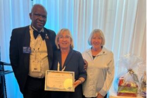 HChristine du Preez (centre) receiving the awards at DISCON 2025